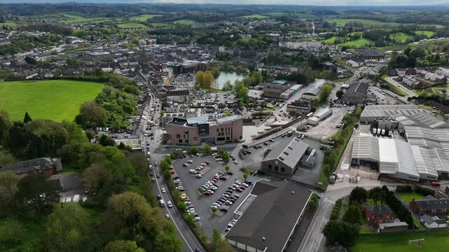 Peace Campus, County Monaghan, Ireland, April 2024. Drone orbits counter clockwise in a wide aerial overview of the Monaghan County Museum with the town and rural green landscape in the background.