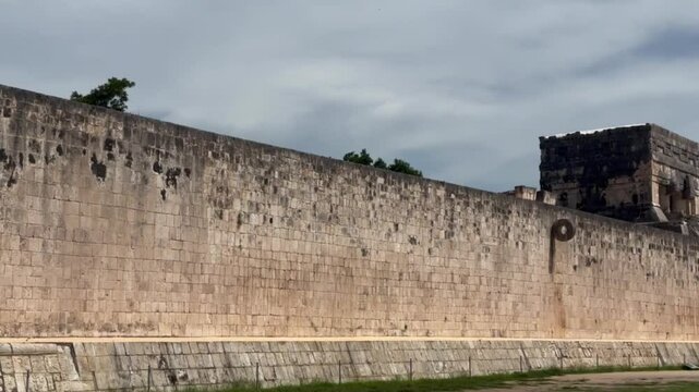 Handheld close-up panning shot of the court wall at the Great Mayan Ball Court in Chichen Itza, Mexico. 4K