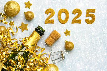 Bottle of champagne with golden christmas balls,golden stars and 2025 in golden numbers. New Years...