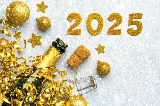 Bottle of champagne with golden christmas balls,golden stars and 2025 in golden numbers. New Years Eve celebration concept background