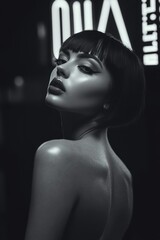 A pale skinned model with bold make-up, chin length haircut, in dark studio. smokey make-up. Fashion. Hairstyle. Cosmetics. Style. Black and white.	
