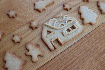 Christmas landscape with trees, house and stars made of gingerbread cookies on wooden table. Festive background