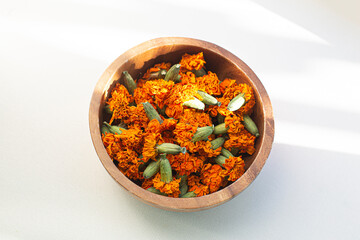 Orange dried marigold flowers on white background.