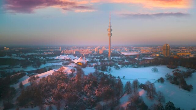 Munich winter snow aerial skyline top view drone footage fly over olympia park tv tower at sunset.