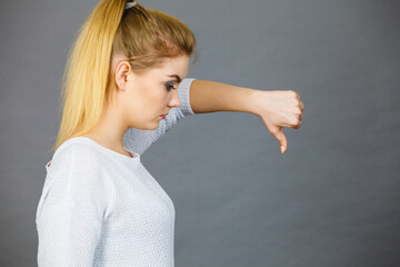 Sad woman showing thumb down gesture