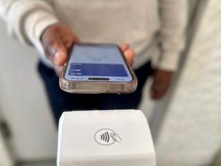 Closeup purchase by smartphone on electronic payment machine or card reader. E-money at cashless...