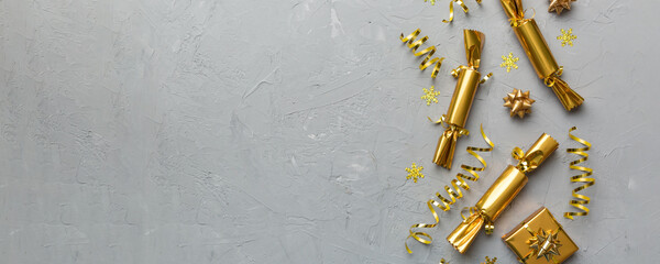 Christmas crackers with shiny confetti on color background, top view, copy space