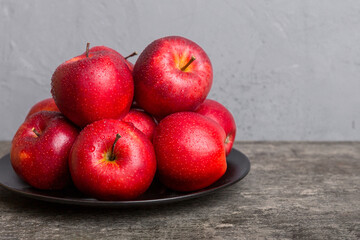 juicy red apples in a bowl or plate on the table top view. Copy space