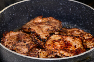 Juicy grilled pork chops sizzling in a skillet on a cozy evening at home