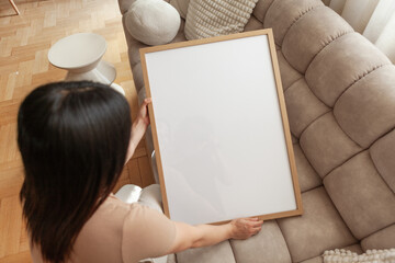 50x70 cm Frame Mockup held by a person in a modern apartment