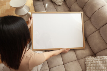 Fototapeta premium 50x70 cm Frame Mockup held by a person in a modern apartment