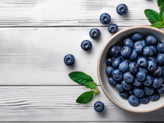 Taz&oacute;n de ar&aacute;ndanos frescos sobre mesa de madera blanca con hojas de menta