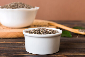Chia seeds in bowl and spoon on colored background. Healthy Salvia hispanica in small bowl. Healthy superfood
