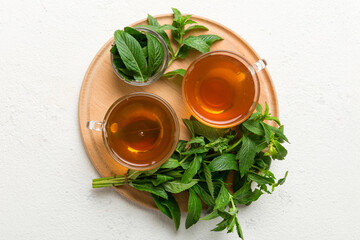 Cup of mint tea on table background. Green tea with fresh mint top view with copy space