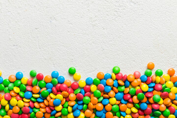 Mixed collection of colorful candy, on colored background. Flat lay, top view. frame of colorful chocolate coated candy