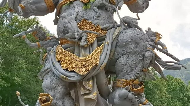 Close-up of a traditional stone statue adorned with intricate gold details, symbolizing Balinese spirituality