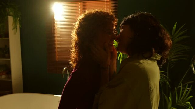 Tender moment in the evening of two multi-ethnic lesbians sharing an intimate moment in the home bathroom