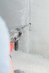 First person view of a hammer drill at work - drilling a hole in a concrete wall