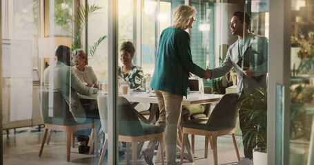 Handshake, meeting and partnership with business people in boardroom of glass office together....
