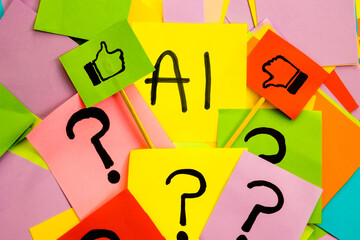 Yellow sticky note with black lettering saying AI with like and dislike flag on colored papers with...