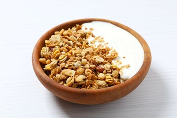 Delicious granola with berries and yogurt on a light background