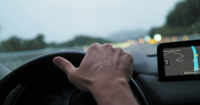 Adjusting hand position on the steering wheel while driving along a highway showcases focus and control in a vehicle