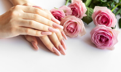 Woman showing her manicure with pink nail polish and roses