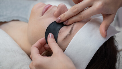 The master applies protective patches that do not let in ultraviolet rays before LED eyelash extensions. 