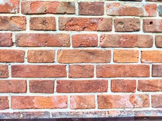 Close-up of a textured red brick wall in a rustic building during daylight