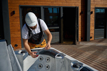 Plumber installing hot tub. Spa technician performing hot tub. Bathtub plumbing. Plumber fixing spa...