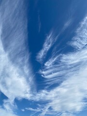 Dynamic cirrus clouds against a vivid blue Sardinian sky, showcasing natural beauty and atmospheric...