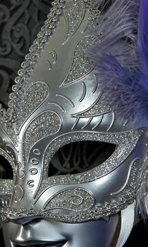 Zoom sur un masque de carnaval argent&eacute; et violet, loup orn&eacute; de plumes violettes pour une ambiance festive et &eacute;l&eacute;gante carnaval de Venise
