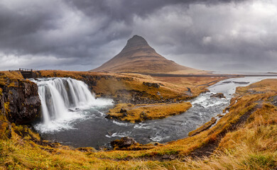 Panorama of the Kirkjufell mountain and Kirkjufellfoss waterfall, Snaefellsnes peninsula, Iceland. Long exposure shot in autumn.