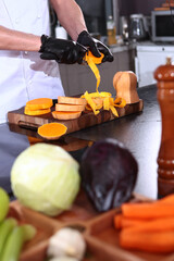 The cook is peeling a pumpkin. Pieces of pumpkin in his hands. Cooking pumpkin soup. The chef prepares a dish of vegetables.