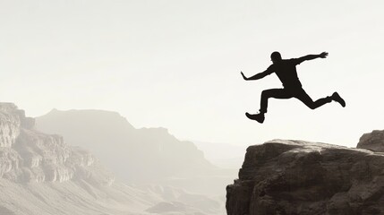 Silhouette of Man Leaping Across Cliff at Sunset in Mountainous Landscape