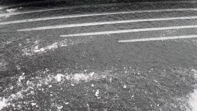 This video showcases the action of defrosting a frozen rear window of a car during winter. The reflective surface glistens as the heating element works to melt the ice, ensuring visibility.