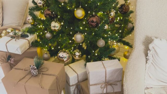 New Year's and Christmas presents lie under the tree. Christmas gifts are waiting to be unwrapped under the Christmas tree. The concept of anticipation and excitement before celebrating Christmas.