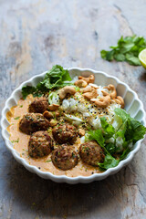 Turkey meat balls in thai curry sauce with rice, coriander and cashew nuts