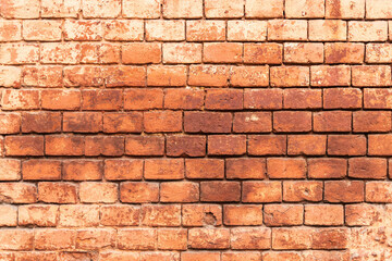 Aged red brick wall with signs of wear and tear. texture background