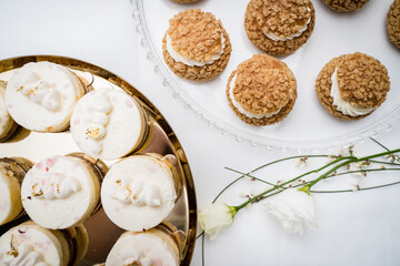 A top-down view of delicate cream-filled choux pastries with a crunchy topping, arranged on a glass stand. The elegant presentation emphasizes the texture and detail of each pastry.
