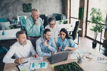 Photo of five successful corporate colleagues chatting desktop laptop loft interior office indoors