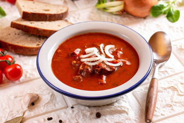 Beef goulash, soup and a stew, made of beef chuck steak and plenty of paprika on table. Hungarian traditional meal.