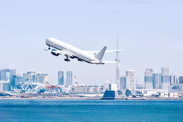 東京の空、スカイツリーを背景に大都会を飛ぶ飛行機