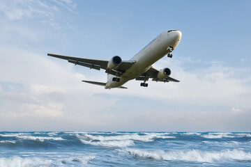 青い空、海の上を飛ぶ飛行機