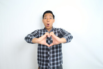 asian man showing heart shape with shocked and funny face wow expression isolated on white