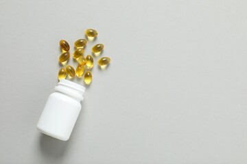 Medicine bottle with pills on a gary background. Fish oil tablets. Biologically active additives....