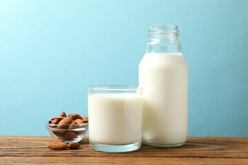 Glass of almond milk with bottle on the table