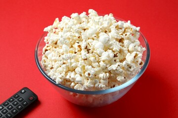 Delicious popcorn in a bowl on a colored background