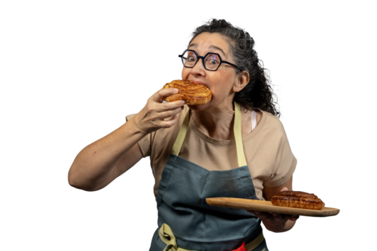 Female baker savoring a delicious pastry, with more on a wooden tray, isolated on white