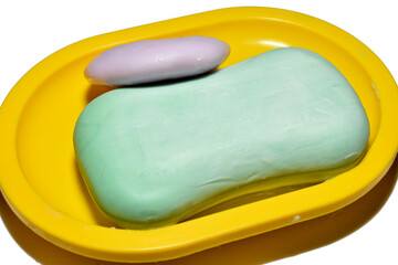 The soap lies in a soap dish, which stands on a white background.